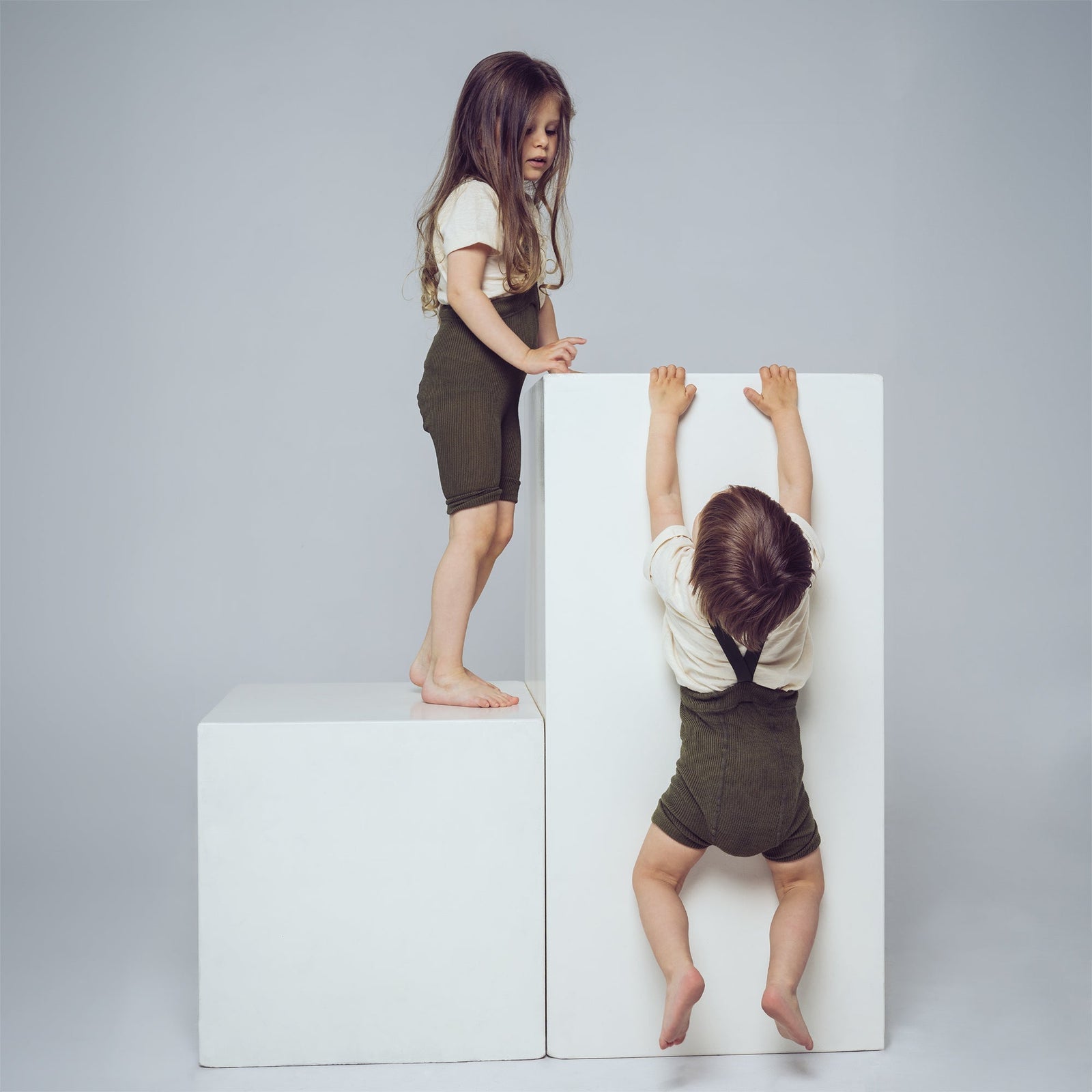 Two children in a photo studio wearing tights.